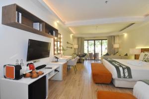 une chambre d'hôtel avec un lit et une télévision dans l'établissement Ambassador In Paradise, à Boracay