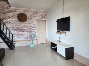 a living room with a brick wall and a fan at Baan Minnie 3 bedroom house 400m from Saikaew beach in Ko Samed