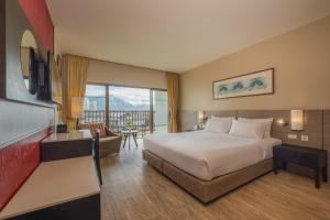 a hotel room with a bed and a balcony at Deevana Plaza Phuket - SHA Extra Plus in Patong Beach