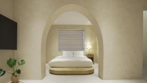 a bedroom with a bed and an arched window at Island Stay in Jeju