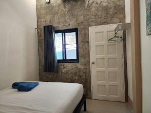 een slaapkamer met een bed, een raam en een deur bij Baan Minnie 3 bedroom house 400m from Saikaew beach in Ko Samed