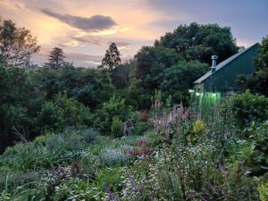 a garden in front of a house with flowers at Little Fields Country House and Cottages in Howick