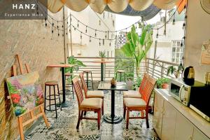 een patio met een tafel en stoelen op een balkon bij HANZ The Galaxy Hotel in Ho Chi Minh-stad