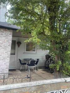 a patio with a table and chairs on a house at Adorable 1-bedroom entire place with free parking in Cambridge