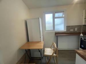 a kitchen with a table and a refrigerator and a chair at Adorable 1-bedroom entire place with free parking in Cambridge