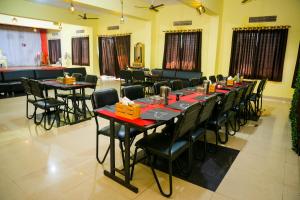 a long tables and chairs in a room at Shubh Parisar in Khandwa