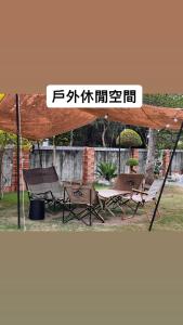 un groupe de tables et de chaises sous une tente dans l'établissement 森林寓, à Minxiong