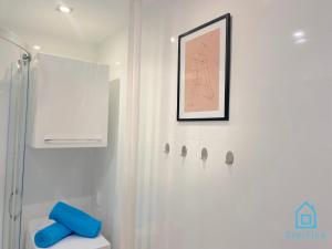 baño con ducha y una foto en la pared en Wave Apartment en Gdansk