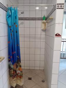 y baño con ducha y cortina azul. en Meri Lodge Huahine « ROOM OF MARTA » en Fare