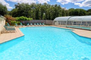 a large swimming pool next to a building at Camping La Mignardière in Ballan-Miré