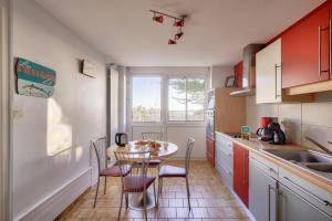 a kitchen with a table and chairs and a window at Charmante escapade avec vue sur le port in Plobannalec-Lesconil