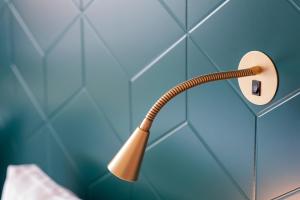 a shower head attached to a blue tiled wall at Apartments By Ligula, Hammarby Sjöstad in Stockholm