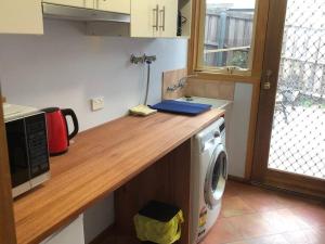 a kitchen with a counter with a washing machine at Sunshine Apartment in Austins Ferry
