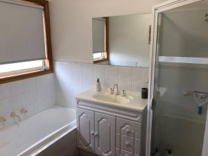 a bathroom with a sink and a tub and a shower at Sunshine Apartment in Austins Ferry