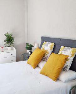 una camera da letto con letto e cuscini gialli di Dehesa Centro a Soria