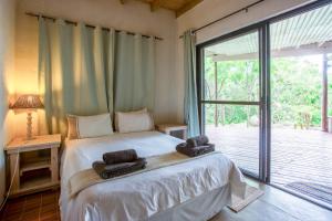 1 dormitorio con 1 cama con 2 toallas en Kangela Estate 14, en Ponta Malangane