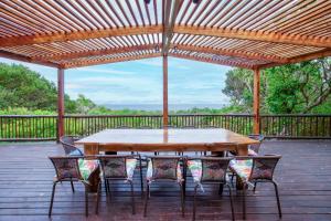 una mesa de madera y sillas en una terraza en Kangela Estate 14, en Ponta Malangane