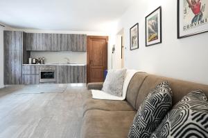 sala de estar con sofá y cocina en Casa dei Ciliegi, en Morgex