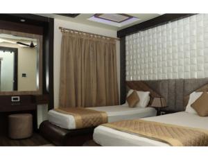 Pearl Heights Hotel, Malda, WB tesisinde bir odada yatak veya yataklar