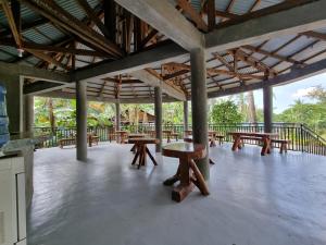 a pavilion with wooden tables and benches in a building at California Breeze Campsite in Indang