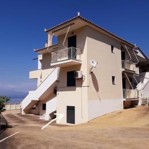 un bâtiment blanc avec un satellite sur le côté dans l'établissement Derveni Seaside Apartments "Groundfloor", à Derveni