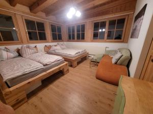 ein Wohnzimmer mit einem Bett und einem Sofa in der Unterkunft Apartmenthaus Edelweiss in Gosau in Gosau