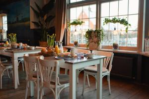 un comedor con mesas, sillas y ventanas en De Postelhoek B&B en Oud-Ootmarsum