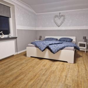 1 dormitorio con 1 cama con un corazón en la pared en Moorparadies FRI-Südliches Friesland, en Bockhorn