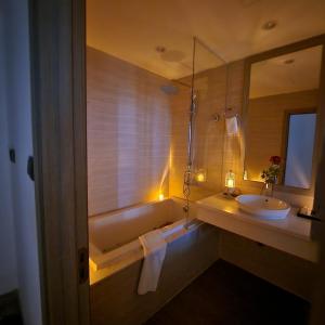 La salle de bains est pourvue d'une baignoire, d'un lavabo et d'un miroir. dans l'établissement The MCR Luxury Nha Trang, à Nha Trang