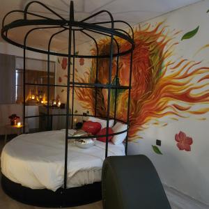 - une chambre avec un lit orné d'une peinture au feu sur le mur dans l'établissement The MCR Luxury Nha Trang, à Nha Trang