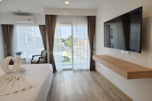 um quarto de hotel com uma cama e uma televisão de ecrã plano em Arsh Boutique Hotel em Chiang Mai