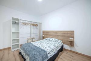 a bedroom with a bed and a book shelf at Apartamentos Avd Xerez in Seville