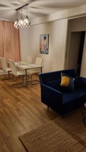sala de estar con sofá azul y mesa en Logement spacieux rénové, calme et proche du métro en Villeurbanne