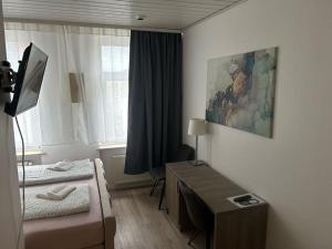 ein Schlafzimmer mit einem Bett und einem Schreibtisch in einem Zimmer in der Unterkunft Pension Sonnenschein in Halle an der Saale