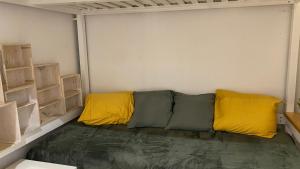 Habitación con sofá y almohadas amarillas y verdes. en Apartamento en el casco antiguo, en Madrid
