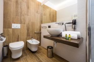 ein Badezimmer mit einem weißen WC und einem Waschbecken in der Unterkunft Corte Ongaro Hotel in Verona