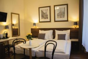 una camera d'albergo con letto, tavolo e sedie di Private Comfort STEPHANSPLATZ - SELF CHECK IN a Vienna