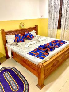 a bedroom with a wooden bed with blue sheets at Mystic Manor Stonetown B&B in Stone Town