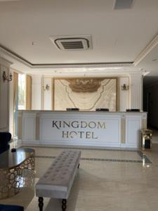 a hotel lobby with a bench in front of a sign at Kingdom Hotel Cua Lo in Cửa Lô