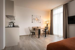 una habitación de hotel con mesa y sillas en una habitación en Atrium Apart Hotel Brühl en Brühl