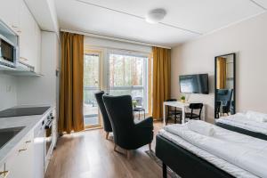 a living room with a couch and a bed in a room at Hiisi Homes Porvoo Toukovuori in Porvoo