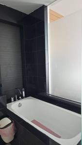 a white tub in a black bathroom with a toilet at KL Q520 Premium Suite Room in Kuala Lumpur