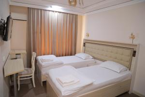 una habitación de hotel con 2 camas y una silla en URGANCH HOTEL, en Urganch