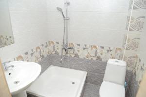 Baño blanco con lavabo y aseo en URGANCH HOTEL, en Urganch