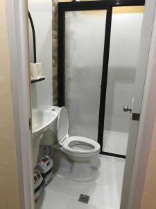 La salle de bains est pourvue de toilettes et d'un lavabo. dans l'établissement Charos Dormitel, à Dumaguete