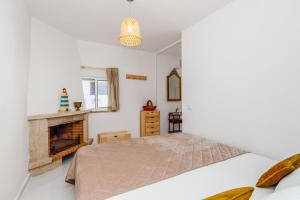 1 dormitorio con 1 cama y chimenea en Gem of Viso, en Setúbal