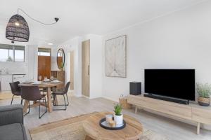 a living room with a large television and a table at Welgelegen 608 in Strand