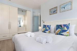 a bedroom with a white bed with towels on it at Pips Place 301 in Strand