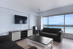 a living room with two couches and a flat screen tv at Pips Place 301 in Strand