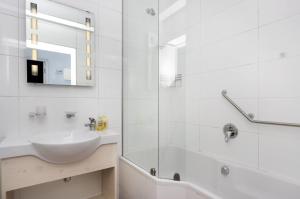 a white bathroom with a sink and a shower at Pips Place 301 in Strand +22 photos